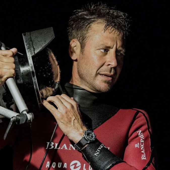 Ambassador Laurent Ballesta holding underwater camera at night.